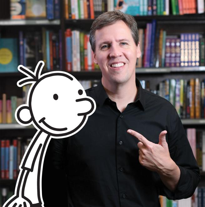 Author Jeff Kinney stands in front a bookcase accompanied by a graphic of Greg from Diary of a Wimpy Kid