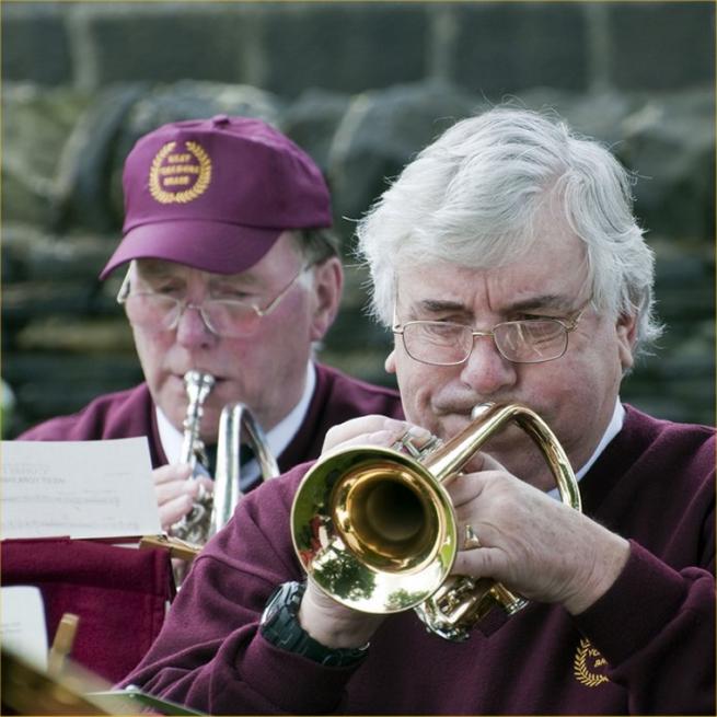 Two musicians performing as part of a brass band. 