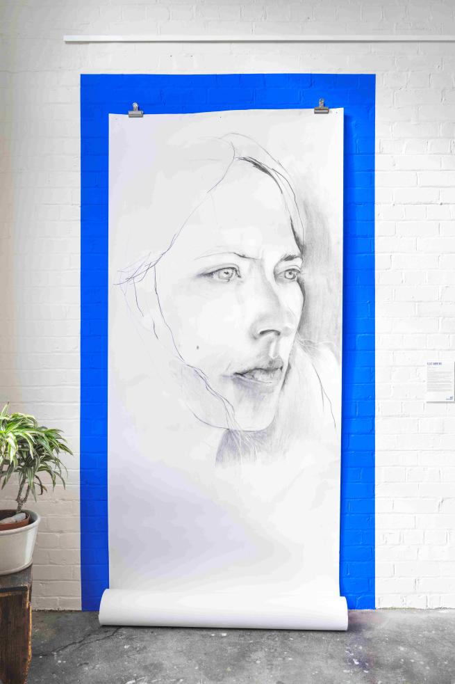 huge drawing of a woman's face on bright blue wall 