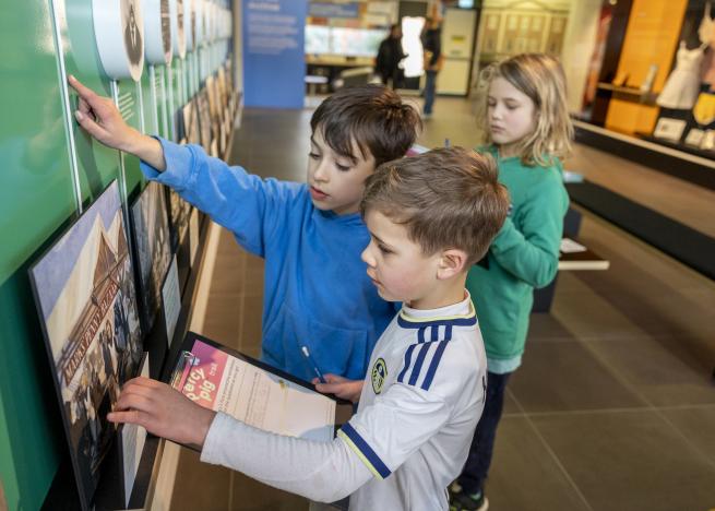 Three children completing a trail at the M&S Archive exhibition