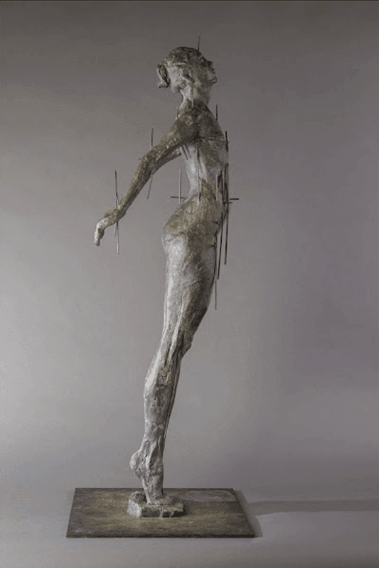 A full female figure on tiptoe, with arms outstretched