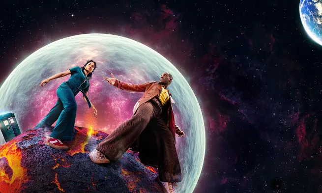 The Doctor and his sidekick walk on a burning comet with the TARDIS behind them and a large planet in the background.