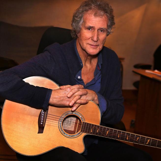 John Illsley with an acoustic guitar.