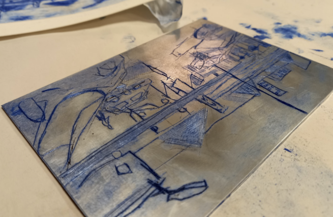 A drypoint printing plate with a street scene, prepared with blue ink for printing from.