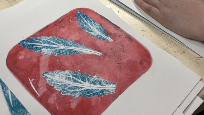 A gelli-printed image of leaves in blue and red