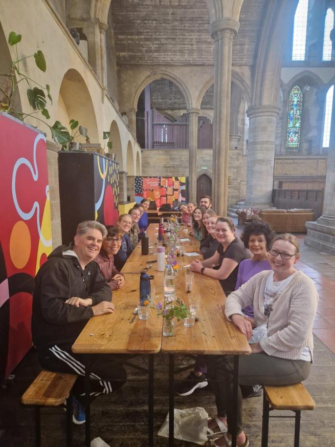 A group of yogis sat around a long table enjoying a brunch.
