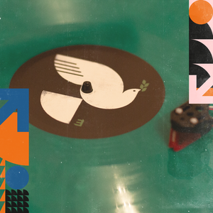 A green vinyl record being played on a turn table.