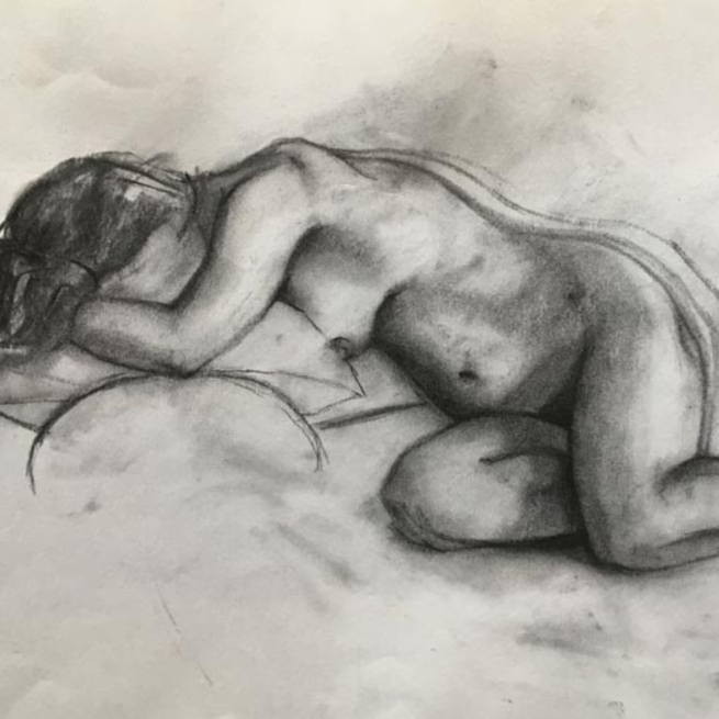 Charcoal sketch of a nude female figure laid on her side, on white paper