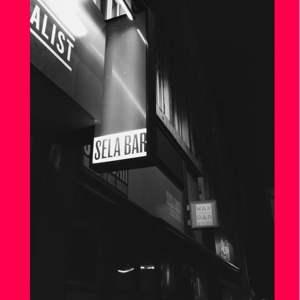 Black & white photograph of outside light box reading 'SELA BAR'