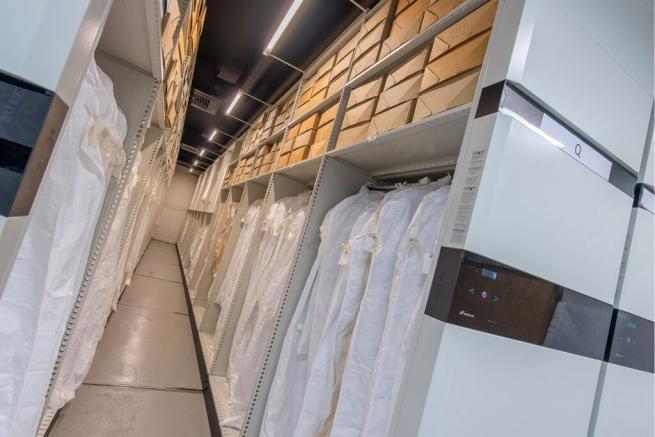 shelves of boxes and racks full of white garment bags in the strongroom at the M&S Archive