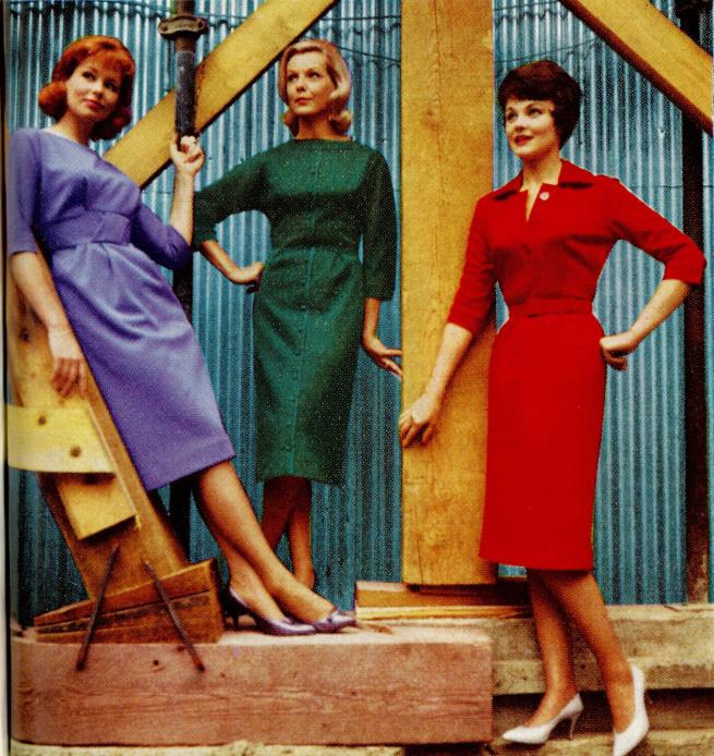 three women in jewel colour outfits pose on a building site