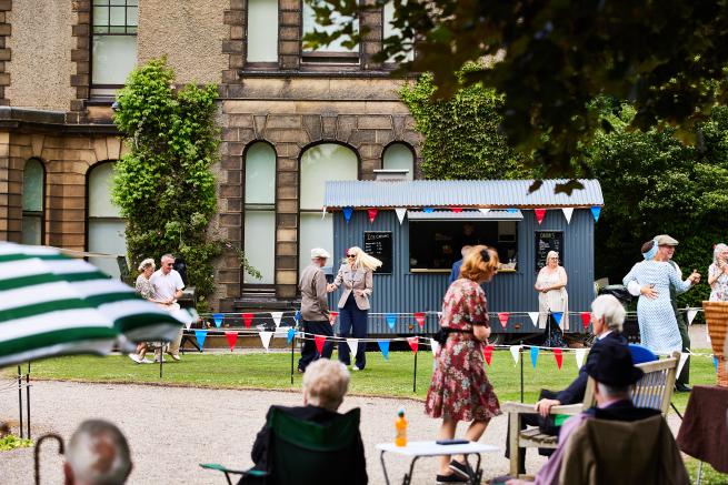 A photograph of people dancing outside Lotherton hall