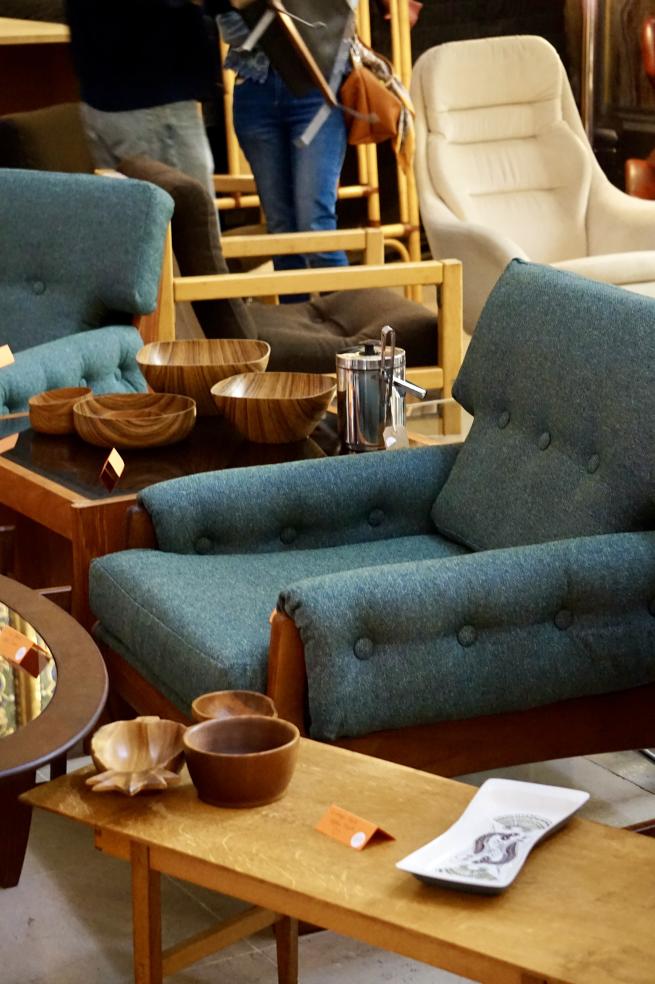 Mid century chair, coffee tables and other homewares at a flea market.