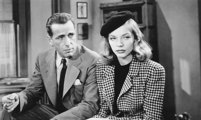 Humphrey Bogart and Lauren Bacall, sat side by side