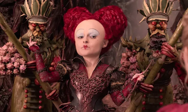 The Queen of Hearts faces the camera with two guards behind her.