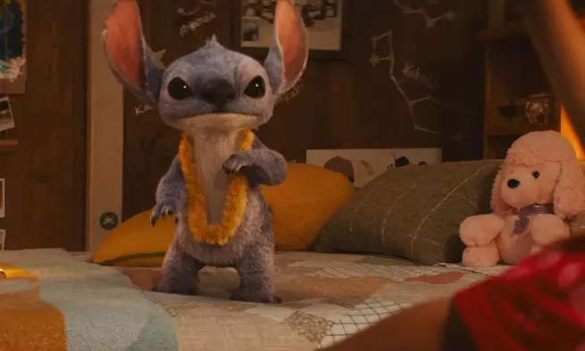 Stitch stands on abed looking alert.