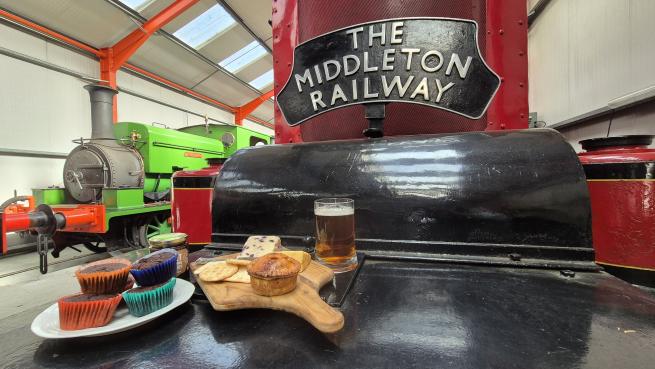 A picture of historic steam and diesel locos in a railway museum with food.
