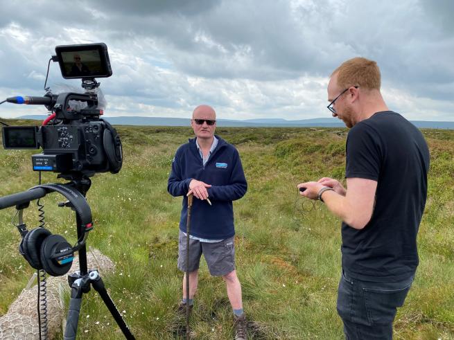A man being filmed at Fleet Moss peatlands