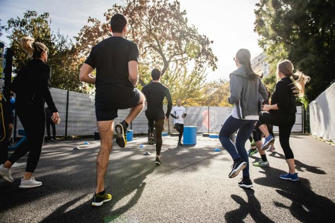 A group of people running on the spot warming up for a boot camp session