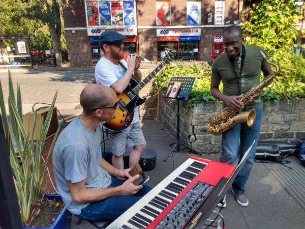 Three musicians playing in the courtyard at Seven Arts 