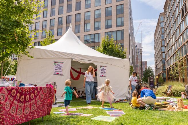 Play tent with children playing in the sunshine.