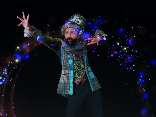 The Hatter character conjures up magical sparkles with his hands.