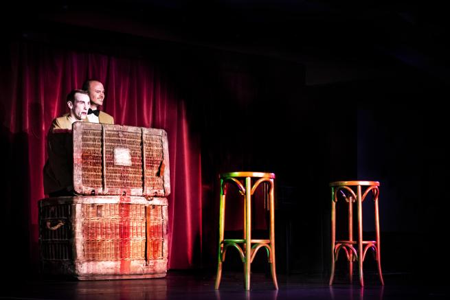 A production photo from Slung Low Shorts 4 showing two actors portraying a ventriloquist and his dummy emerging from a basket.