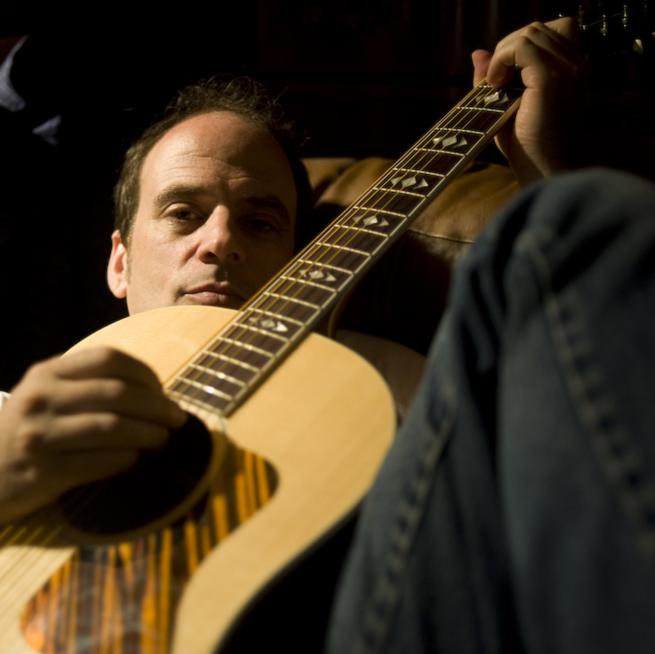 A photo of Antifolk founder Lach with his guitar