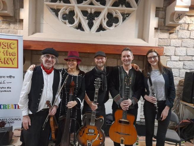 Gypsy Swing Collective standing with instruments 