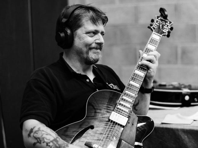Nigel Price, seated, with guitar
