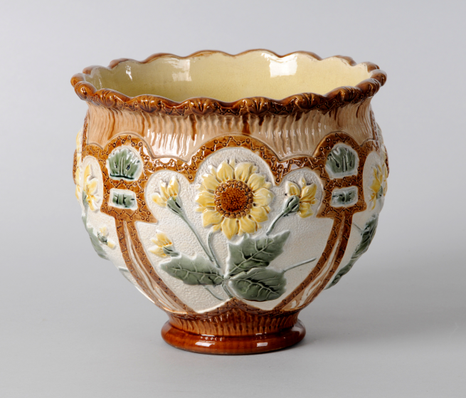 Ceramic plant pot decorated with a large yellow sun flower. 