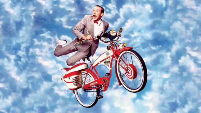 Pee-Wee Zooming across a cloud filled sky on his beloved bike