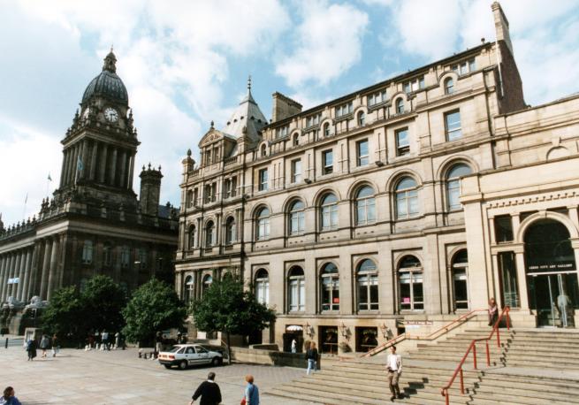 Photograph of Leeds Central Library with Leeds Town Hall to the left with large clock tower.