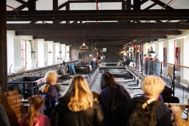 an audience watching a big industrial mule in a mill space