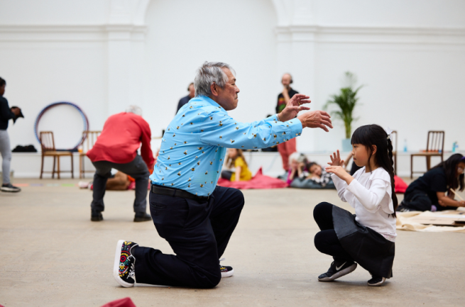 An older man and a young girl perform