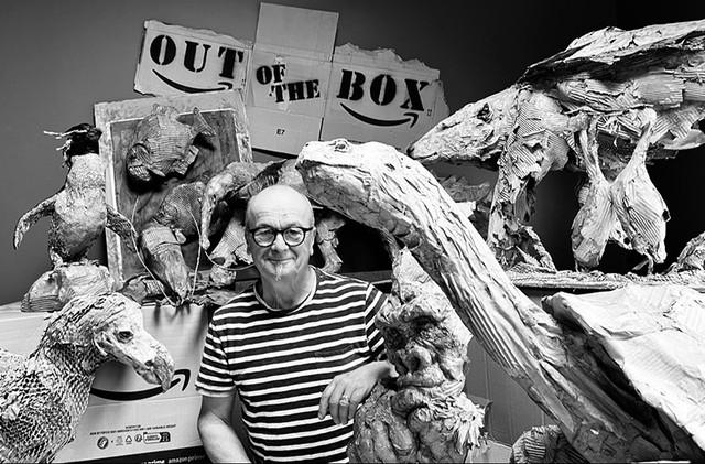Sculptor surrounded by his various pieces, made from different materials.