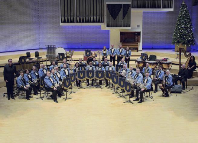 A brass band sat in a circle ready to perform. 