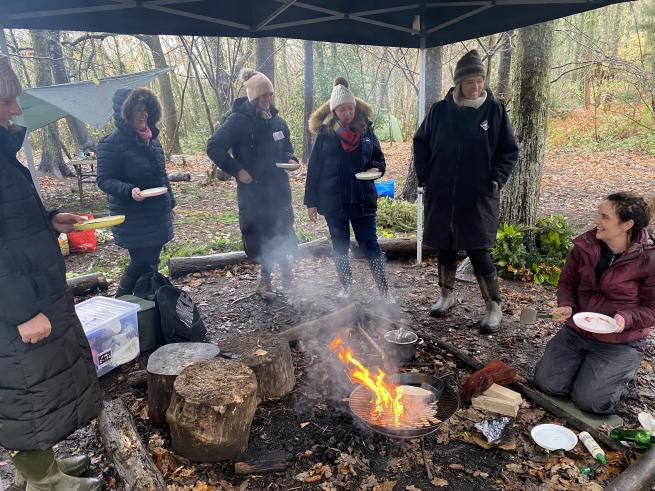 Photograph of women at a campfire