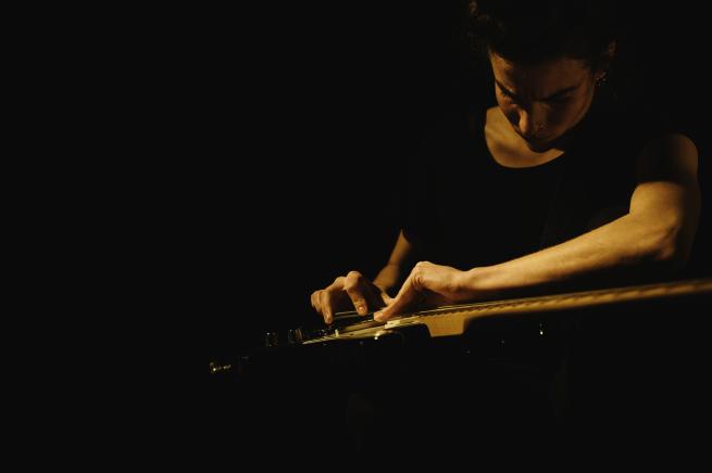 A woman playing the guitar.
