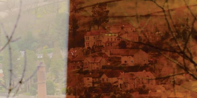 View of buildings in a valley, taken from a video still.