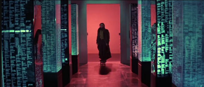 A man skateboards down a futuristic corridor