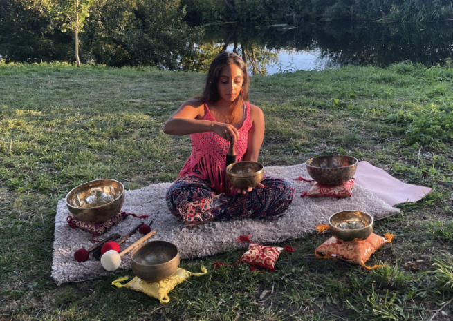 Neeta sat with her Himalayan singing bowls and bells on a blanket in the park on a warm day
