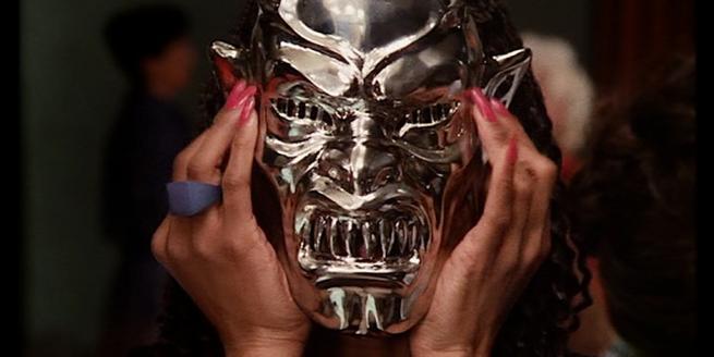 Still from the film Demons someone with a mask over their head 