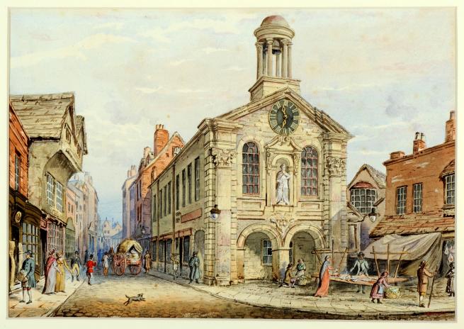A watercolour painting of a large civic building with a clock, statue and dome (cupola) in the centre of a busy market street about 200 years ago. This is a painting of the Leeds Moot Hall on Briggate by Walter Braithwaite.