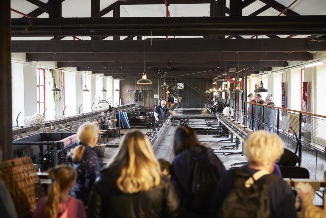 A family look on at a heritage working loom.