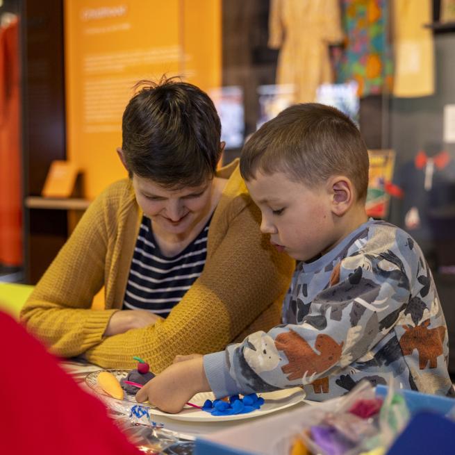 A woman and a child making something crafty in the M&S Archive exhibition