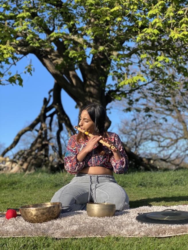 Neeta from Sarl Sound Healing sitting under a tree with her instruments