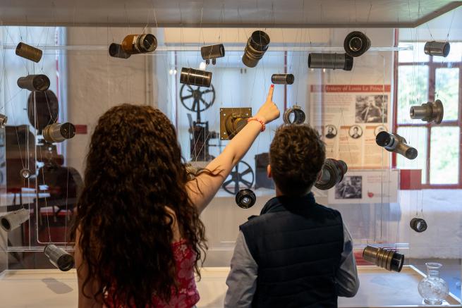 2 people looking at museum displays of cinema lenses