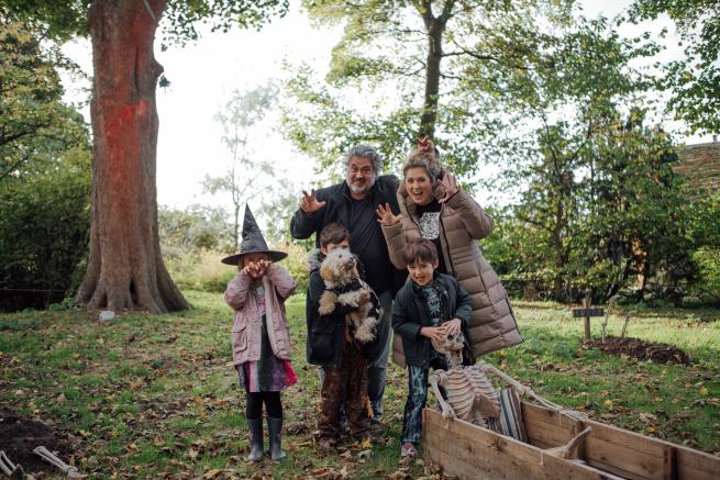 A family pose next to skeleton from the Scarytales trail.