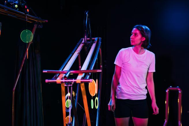 A woman stands by a self constructed machine